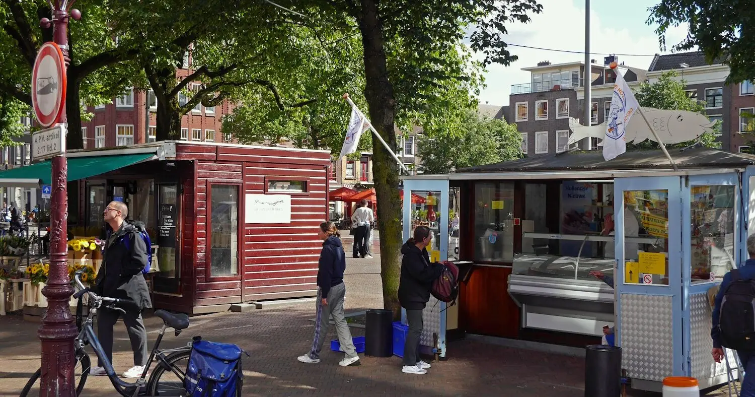 Passants devant les étals d'un marché de rue à Amsterdam